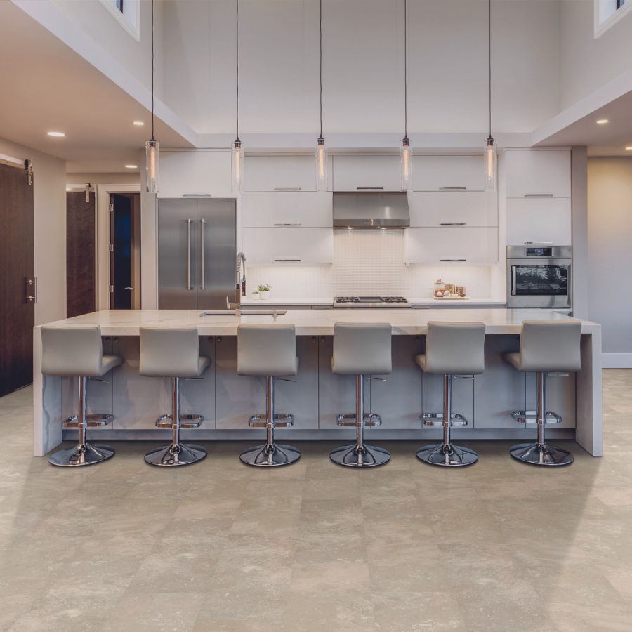 stone look tile flooring in modern kitchen with waterfall marble countertop kitchen island and gray swivel stools